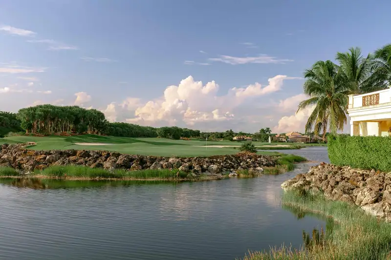 A lake and golf fairway at Miromar Lakes in Estero, Florida, framed by palm trees