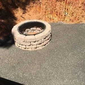 Stone fire pit on a level pad cut back into a red clay bank