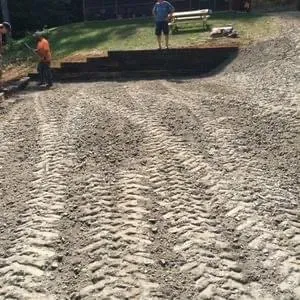 Graded and leveled gravel pad for RV parking beside a timber retaining wall